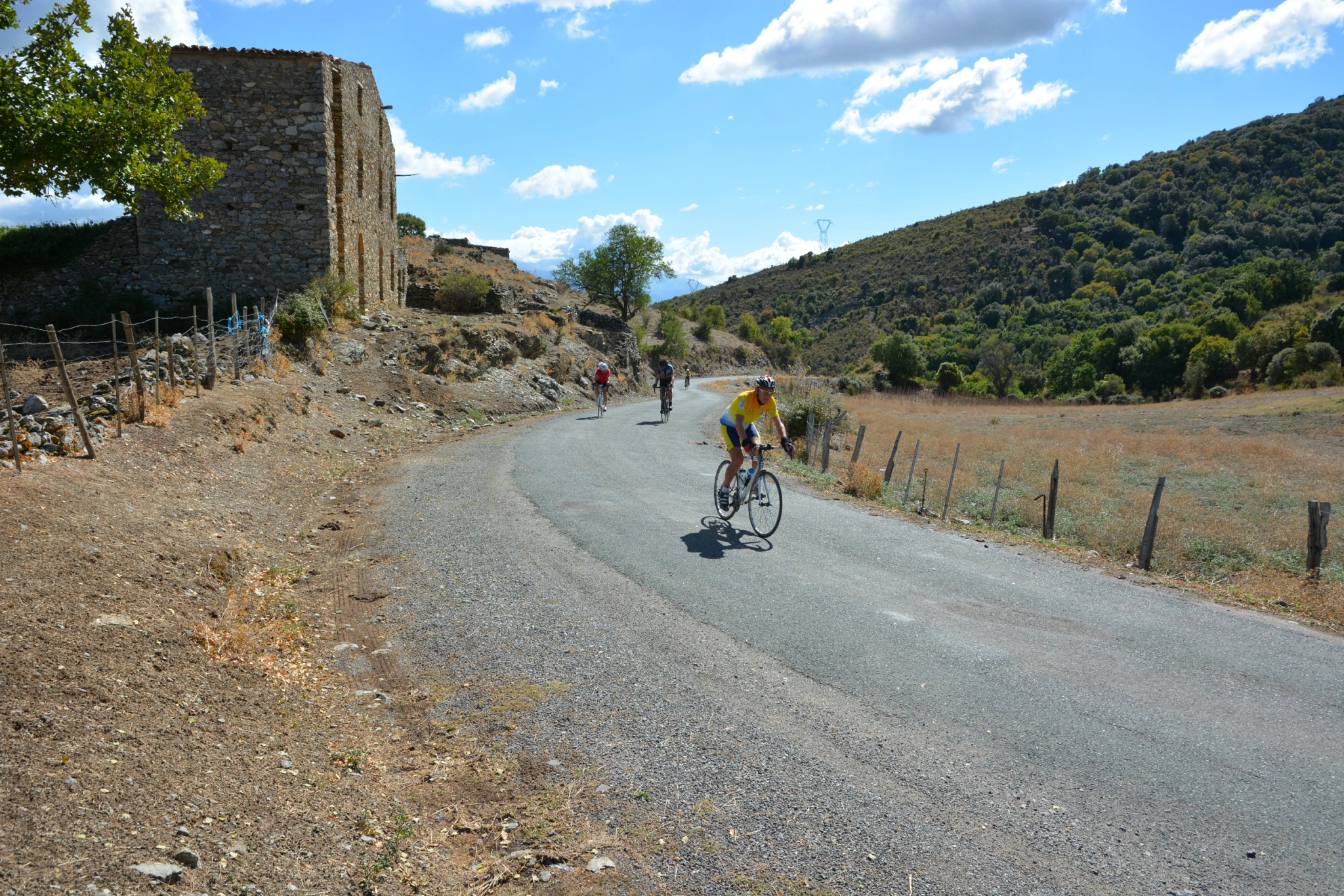 Cycliste roulant sur une route de campagne en Corse.
